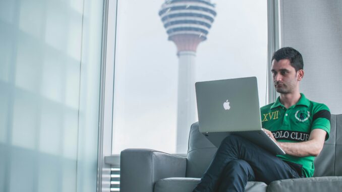 Man working on a computer illustrating a report from the Tony Blair Institute highlighting AI's potential impact on the workforce, including the opportunities and risks to the labor market and how government and policymakers can mitigate the challenges.