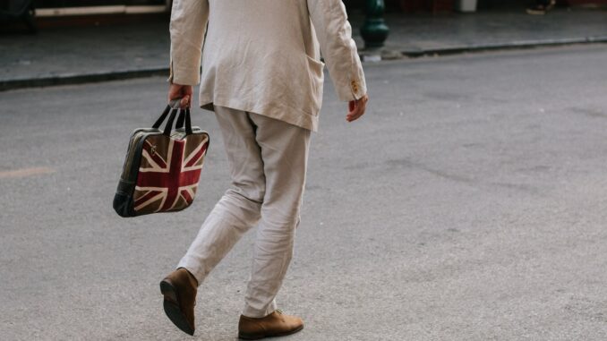 Photo of a man carrying a bag with the Union Jack flag of the UK as Prime Minister Keir Starmer unveils an AI action plan aiming to harness artificial intelligence technologies to unlock economic potential, transform public services such as the NHS, and more.